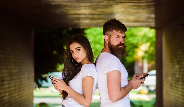 Paar chatten Smartphones. Mädchen attraktiven brünetten bärtigen Hipster-Mann stehen Rücken an Rücken Veranda U-Bahn-Kreuzung. Paar ignoriert echte Kommunikation. Kommunikationsprobleme. Virtuelle Beziehung — Stockfoto