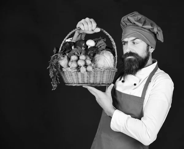 Chef holds cabbage, radish and lettuce. Man with beard holds veggies on black background. — Stock Photo, Image