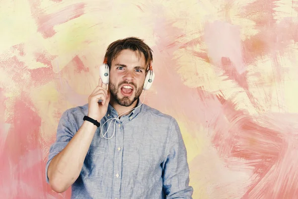 Smartphone ile mavi gözlü şık hippi. Müzikal yaşam tarzı. Neşeli genç dj dinleme şarkı yolu ile kulaklık.