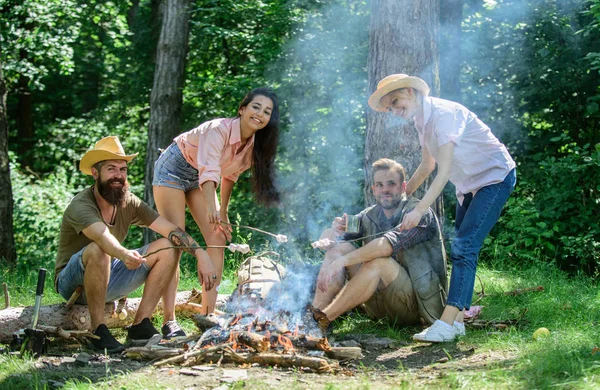 Friends relaxing near bonfire. Friends enjoy picnic eat food nature forest background. Pleasant hike picnic in forest. Company friends or family picnic roasting food. Plan for perfect day hike picnic — Stock Photo, Image
