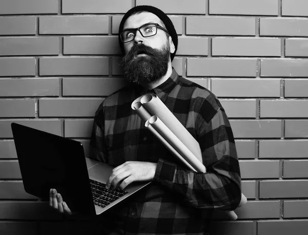 Barbu brutal caucasien hipster tenant ordinateur portable et artisanat papier — Photo