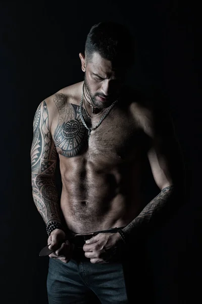 Uomo con disegno del tatuaggio sulla pelle. Uomo barbuto senza maglietta con busto in forma. Modella fibbia cintura in pelle jeans. Sportsman con sei pack e ab. Fitness con sport e cura del corpo, filtro vintage — Foto Stock