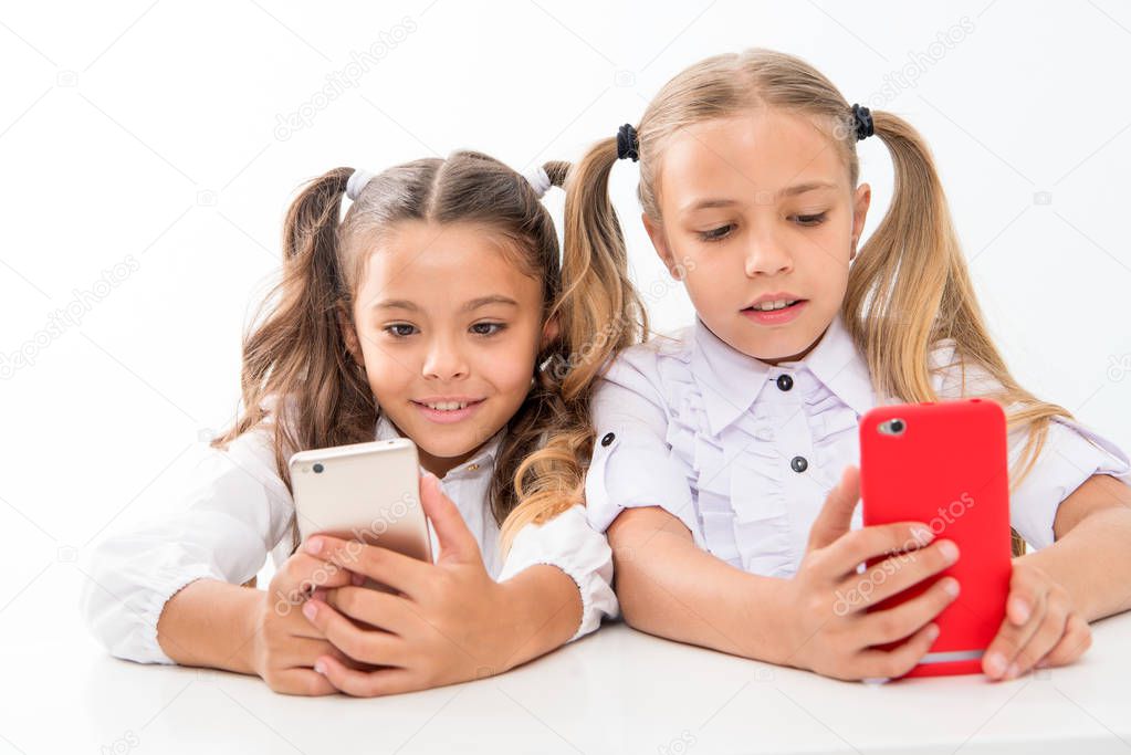 Educational application. Online life concept. Schoolgirls cute pupils use smartphones big diagonal screen check social networks. Send message friend. Online communication messaging. Game application