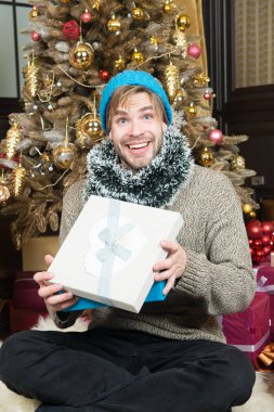 Hediye kutusu ile mutlu adam oturup Noel ağacı