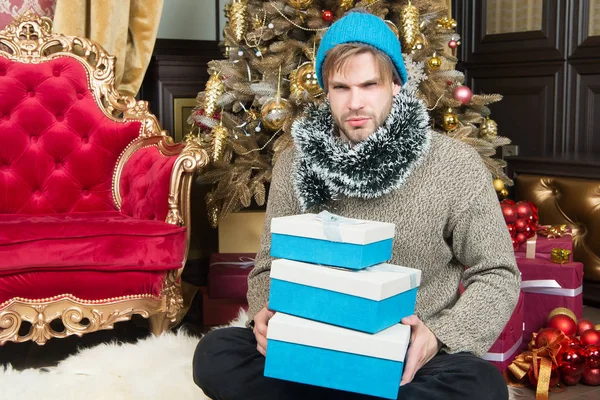 Chico con serias cajas de regalo en el árbol de Navidad — Foto de Stock