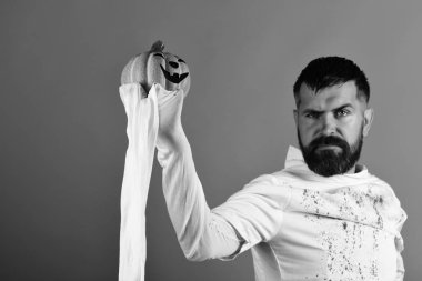 Adam kırmızı bir arka plan üzerinde ciddi bir yüz ifadesi ile