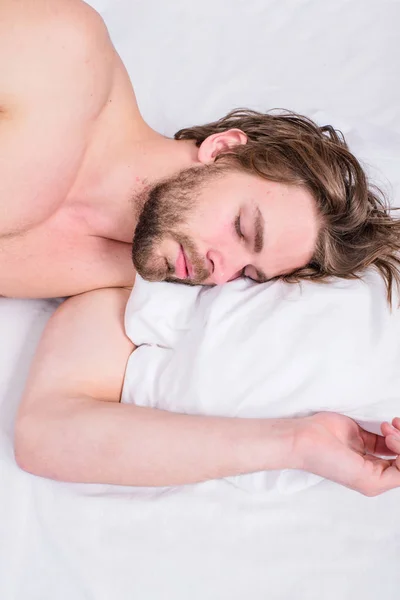 Aangename ontwaken concept. Man ongeschoren knappe jongen naakte torso ontspannen bed bovenaanzicht. Guy sexy macho leggen wit beddengoed. Man slaperig slaperig bebaarde gezicht rust. Guy slaperig ochtend nap — Stockfoto