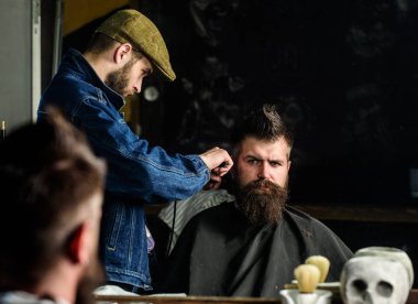 Hipster istemci Başlarken saç kesimi. Kuaför saç kesme makinesi ile saç modeli sakallı, berber arka plan için çalışır. Styling saç kesme makinesi ile acımasız sakallı istemcisinin berber. Saç kesimi kavramı