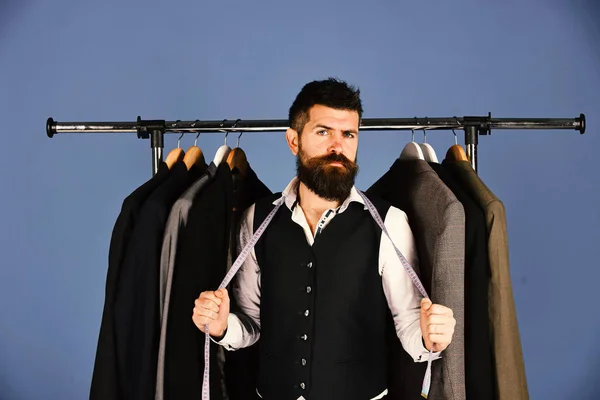 Man met baard bij kledingrek. Ontwerper neemt maatregelen — Stockfoto