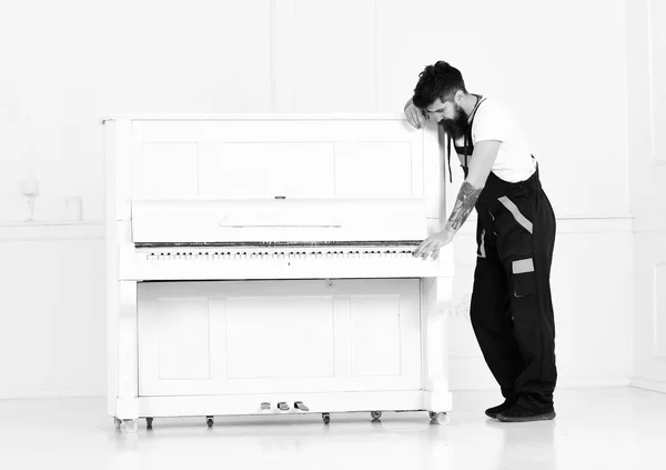 강한 남자 오픈 키보드 흰색 배경에 고립 된 오래 된 나무 피아노 이동 수염. 잘생긴 남자가 쉽게 연주 피아노에 조정 — 스톡 사진
