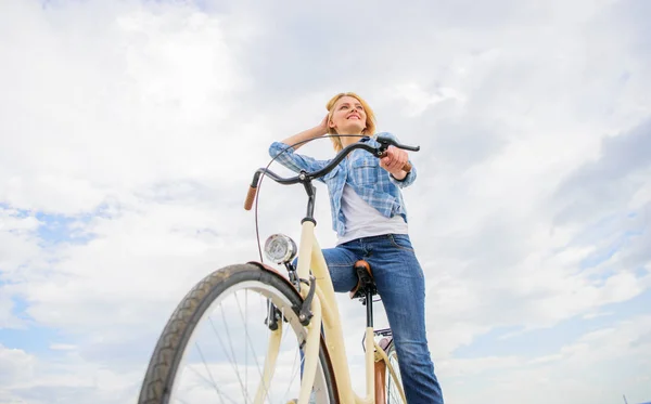 Dziewczyna jeździ rowerem na tle nieba. Kobieta wypożyczyć rower i zwiedzić miasto kopiować przestrzeń. Wypożyczalnia rowerów sklepów przede wszystkim służyć ludzi, którzy nie mają dostęp do pojazdu zazwyczaj szczególnie turystów i — Zdjęcie stockowe