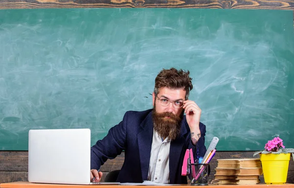 Profesor formal desgaste sentarse mesa aula pizarra fondo. Maestro barbudo concentrado maestro de escuela maduro escuchando con atención. Presta atención a los detalles. Profesor escuchando respuesta o informe — Foto de Stock