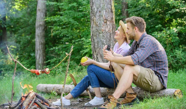 Couple relaxing sit on log having snacks. Family enjoy romantic weekend in nature. Pleasant picnic or romantic date nature background. Couple romantic date near bonfire in forest. Hike picnic date — Stock Photo, Image