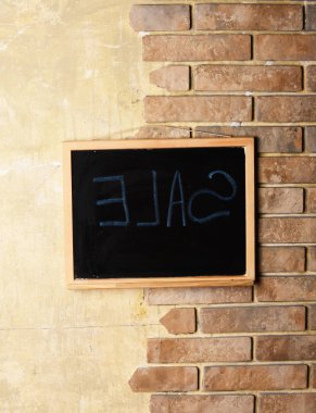 Ahşap dokulu pastel ve tuğla duvar arka plan karede satışında metin ile yazı tahtası.