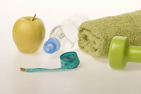 Cloches en plastique près de la pomme verte. Haltères et fruits — Photo