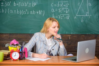 Öğretmen kadın tablo iş dizüstü sörf internet kara tahta arka plan otur. Kapsamlı şekilde mevcut ders görsel öğrenme kolaylaştırmak için kullanın. Sınıf organize etmek ve kolay işlem öğrenme