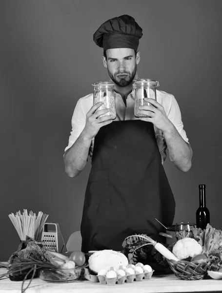 Cook arbetar i kök nära bord med grönsaker och verktyg — Stockfoto