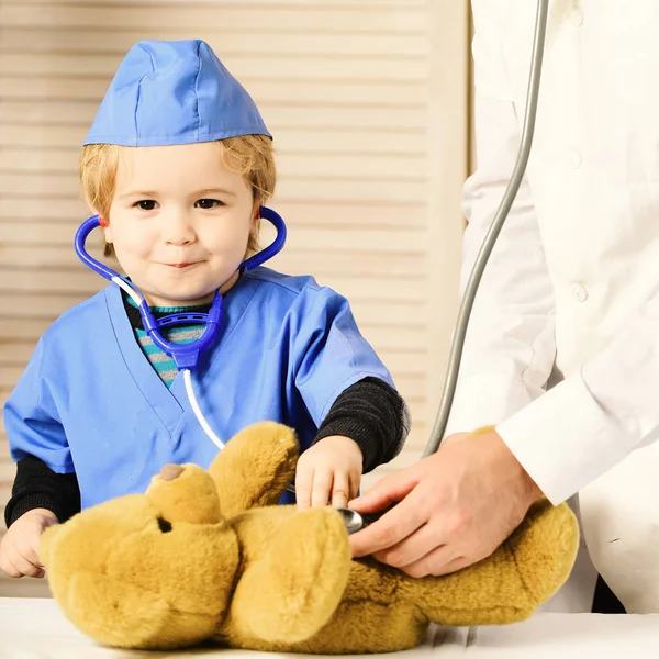 Concepto de salud e infancia. Pequeño asistente examina osito de peluche . — Foto de Stock