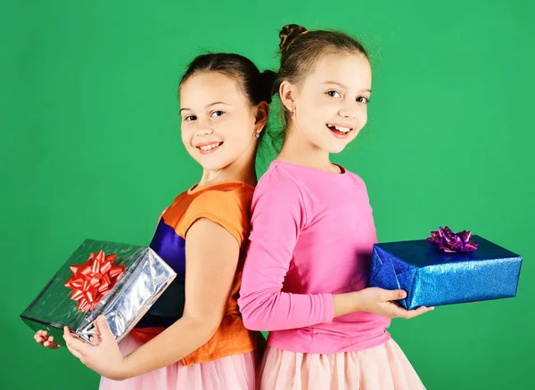 Children open gifts for Christmas. Girls with smiling faces