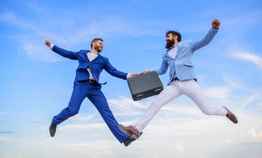 Başarılı işlem işadamları arasında. Evrak Çantası'nın devir teslim cennet mavi gökyüzü arka planda. Kolay anlaşma iş. İşadamları sinek orta hava tutun evrak çantası sırasında atlamak. İle durum yükseltmek iş