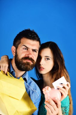 Sakallı adam ve ciddi yüzler kızla yapmak alışveriş.