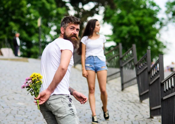 Strauß immer gute Idee. Überraschung für sie. Paar trifft sich zum Date Park Hintergrund. Kerl bereitete Überraschungsstrauß für Freundin vor. Mann versteckt Blumenstrauß hinter Rücken, während Mädchen romantisches Date erwartet — Stockfoto