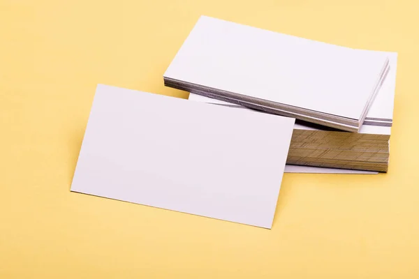 Concepto de contactos comerciales. Las tarjetas de visita se apilan sobre fondo amarillo. Tarjetas de nombre en blanco — Foto de Stock