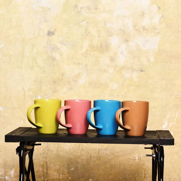 Mesa baixa moderna com tampas de chá ou café perto da parede. Escritório acolhedor e conceito de coffee break . — Fotografia de Stock