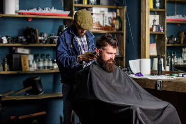 Hipster istemci Başlarken saç kesimi. Kuaför saç kesme makinesi ile sakallı adam berber arka plan saç kesimi üzerinde çalışır. İstemci ense üzerinde kırpma makası kesme saçlı berber. Hippi saç modeli kavramı