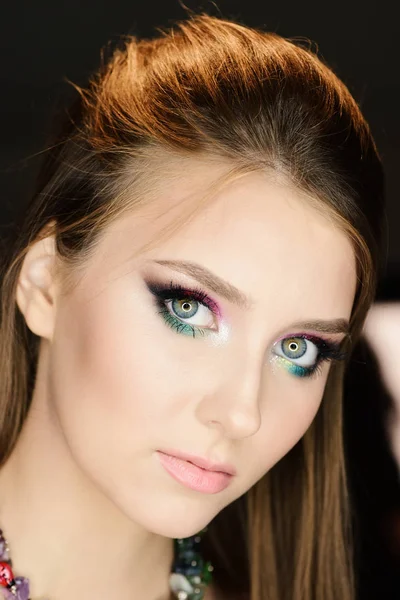 Ragazza con trucco colorato e capelli lunghi, attenzione selettiva. Signora con look seducente e trucco colorato su sfondo nero — Foto Stock