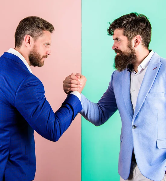 Business partners competitors office colleagues tense faces ready to compete in arm wrestling. Hostile or argumentative situation between opposing colleagues. Business competition and confrontation — Stock Photo, Image