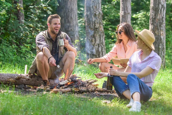Hikers on picnic. Spend great time on weekend. Company hikers at picnic roasting marshmallows snacks eating food. Take a break to have snack. Company friends eat food snack nature background