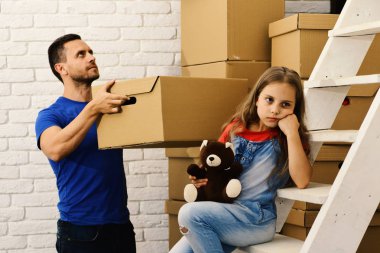 Üzgün ya da sıkılmış yüzlü baba ve kız. İçeri giriyoruz.