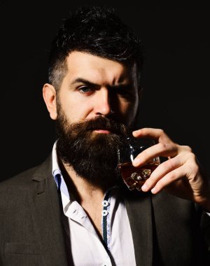 Ciddi yüzlü bir adam bir bardak alkolle kadeh kaldırıyor.