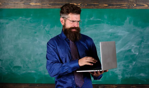 Éducation aux technologies modernes. Éducation aux technologies numériques. Commence la leçon. Professeur barbu homme avec fond moderne tableau noir ordinateur portable. Hipster professeur porter des lunettes et cravate détient ordinateur portable — Photo