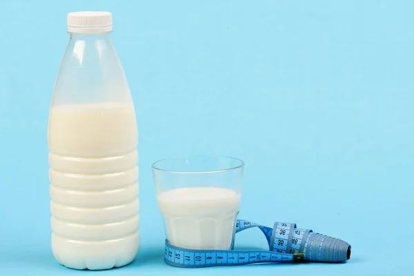 Flasche und Glas Milch mit Klebeband auf Cyan-Hintergrund — Stockfoto