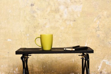 Sıcak çay ve yapım notları kavramı. Defter ile tablo duvarının yakınında yer işareti, kalem ve yeşil bardakta. Çay ya da kahve modern iç düşük siyah tablo. Kalem ve sıcak içecek kapalı yeni fincan ile günlüğü