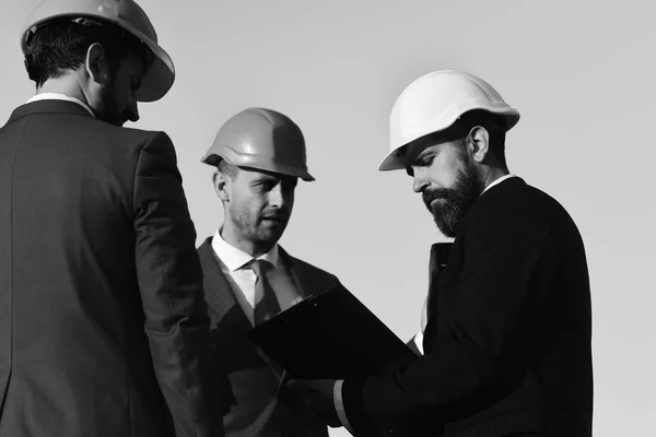 Les constructeurs tiennent le dossier clip. Concept de construction et d'ingénierie. — Photo