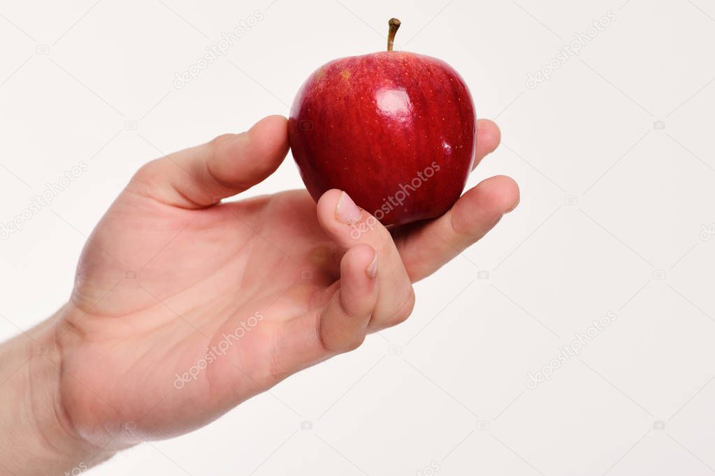 Vitamins and fitness concept. Male hand holds red apple.
