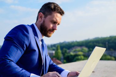 Nasıl yüksek yanıt oranları almak. Oranları online satış ipuçları artırın. İşadamı sörf internet veya yanıt e-postalar ile dizüstü bilgisayar açık havada oturup süre. Internet Pazarlama Yöneticisi mavi gökyüzü arka plan çalışır?