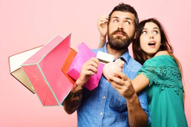 Sakallı adamın elinde kredi kartı ve para kutusu var.