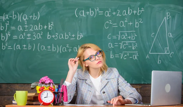 Crear y distribuir contenido educativo. Presentar la lección de manera integral para facilitar el aprendizaje. Promover el aprendizaje interactivo. Profesor mujer sentarse mesa aula pizarra fondo — Foto de Stock