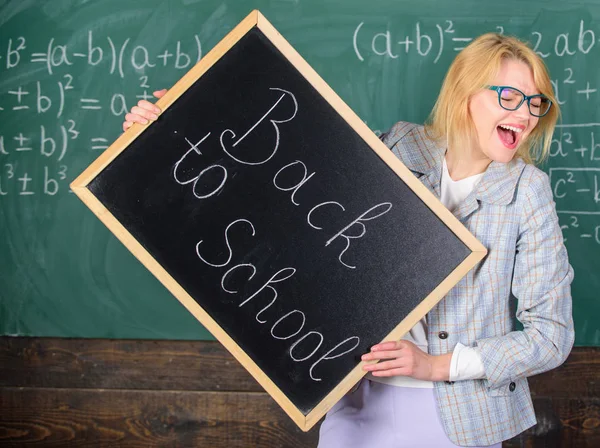 Le costume officiel d'enseignante tient l'inscription du tableau noir à l'école. Enseignant informe sur le début de l'éducation. Dame éducatrice en classe se préparer pour la nouvelle année scolaire. Début de la nouvelle saison scolaire — Photo