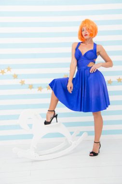 Kimi isterse evcilleştir. Komik ve komik bir kavram. Oyuncu ama kendine güvenen bir kadın eğleniyor. Atı evcilleştirmek için asla geç değildir. Güzellikte kızların gücü. Kızıl saçlı bayan peruk mavi elbise ve sallanan at