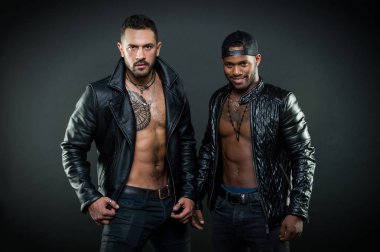 Maço kas torsolar ile deri ceketler, koyu arka plan çekici görünüyorsun. Erkeklik ve vahşeti kavramı. Seksi kas torsolar erkeklerle vahşice bak. Erkekler kendine güvenen yüzleri ile kıl