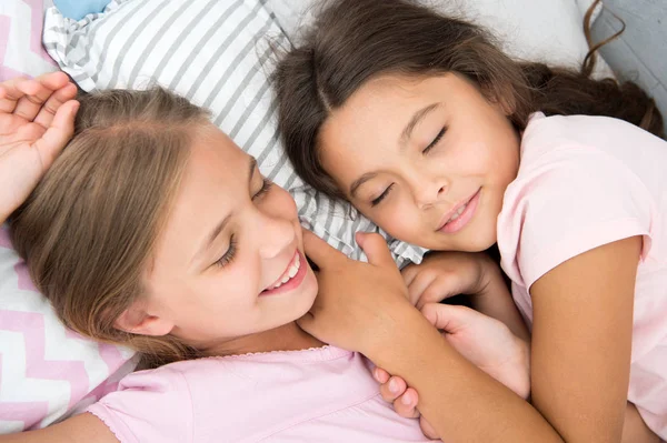 Angenehmer Traum im Kopf. Mädchen schlafen nach Pyjama-Party im Schlafzimmer ein Mädchen schlafen gesund. Kinder entspannen sich im Bett. Schläfrige Kinder im Schlafanzug, die sich auf einem bequemen Bett ausruhen. Glückliche Kindheit — Stockfoto