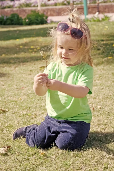 Piccolo bambino con la faccia felice su erba verde — Foto Stock