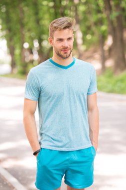 Refah ve sağlıklı vücut keyfini çıkarın. Adam sportif kıyafeti kendine güvenen açık havada doğa arka plan görünüyor. Adam kas vücut onun sportif şeklinde gurur sakallı. Sporcu kas vücut sabah çalıştırmak için hazır