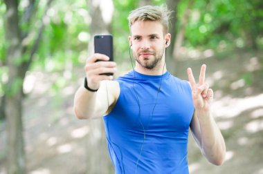 Adam atlet yüz almak smartphone fotoğraf doğa geçmiş yoğunlaşmıştır. Sporcu almak fotoğraf kazanan spor yarışması. Atlet fitness izci ve smartphone. Zafer anı yakalamak. Zafer jest