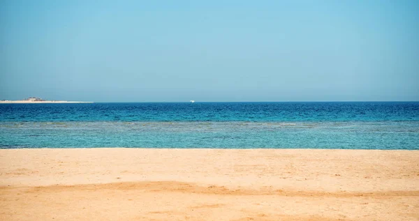 Mooi strand met zand, blauwe lucht, water met boot — Stockfoto